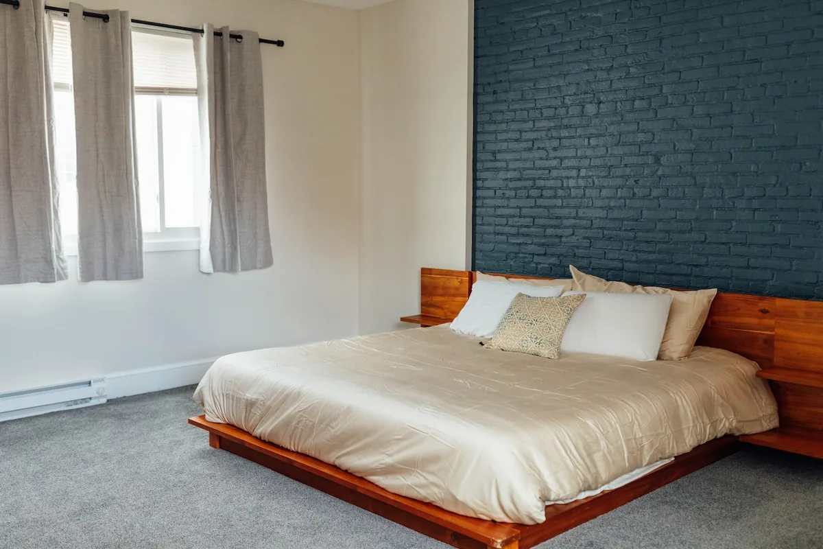 King bedroom with painted brick accent wall at the Downtown Condo