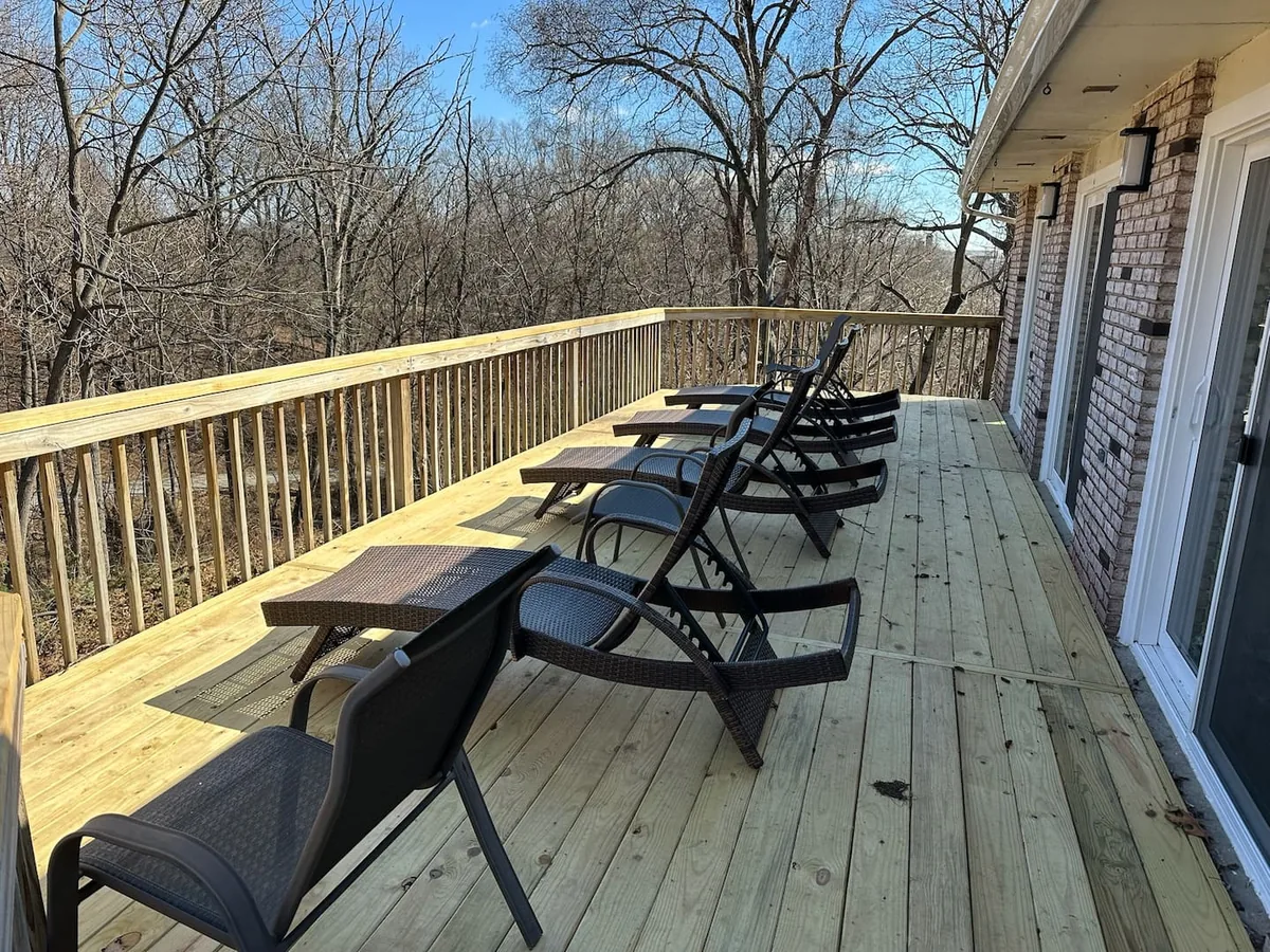 Deck with lounge chairs overlooking the woods at Ferncliff Cottage
