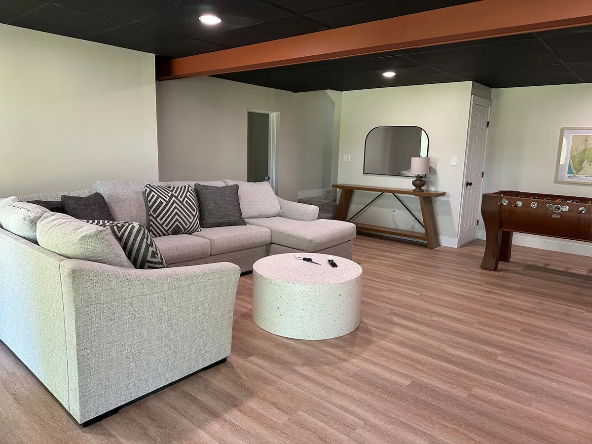 Living room with sectional and foosball table at Ferncliff Cottage
