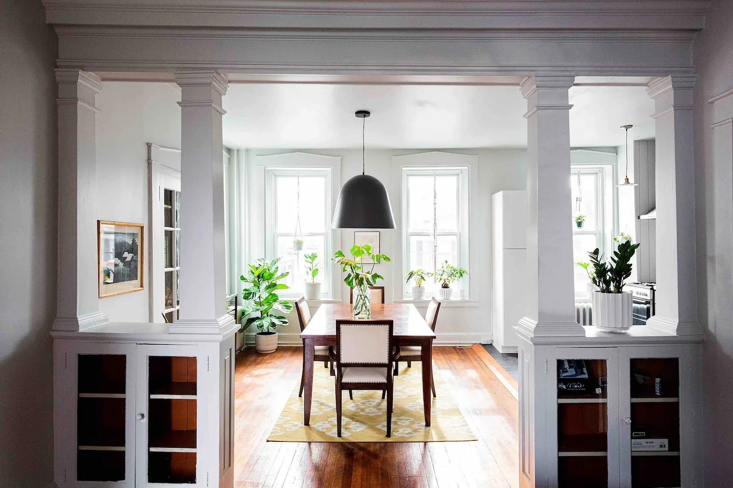 Sunlit dining room with original columns at the Greenhouse on Walnut