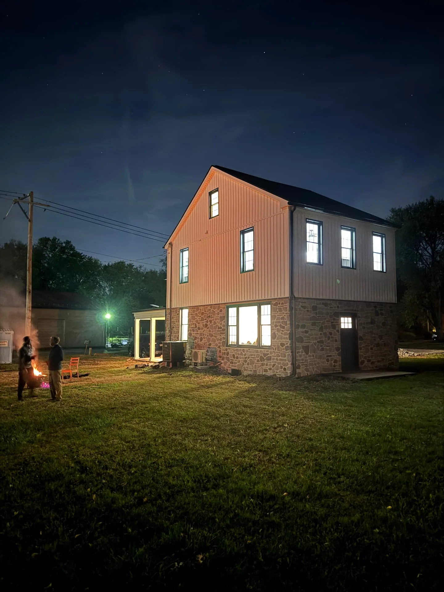The Marietta Bike House lit up at dusk with a fire pit in the yard